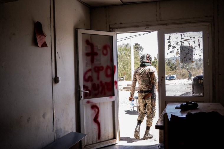 Image: An Amhara militia member walks out from a looted police station in Kombolcha, Ethiopia, on Dec. 11, 2021.
