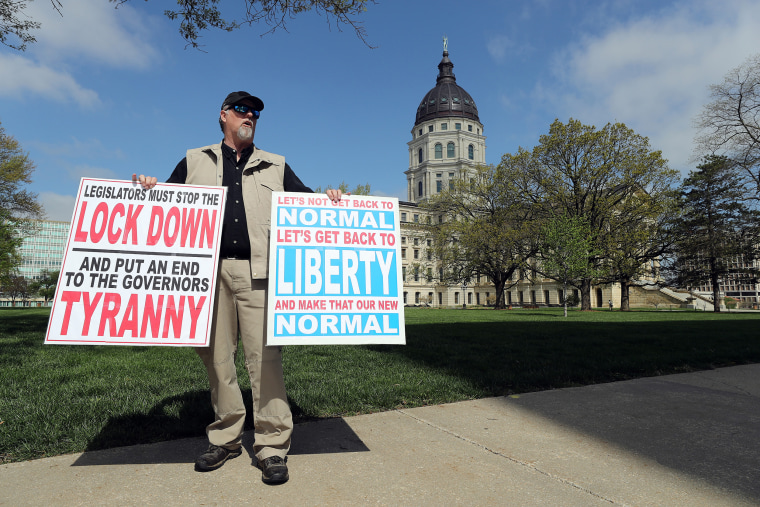 Image: A protester outside the state capitol building demanding that businesses be allowed to open up, people allowed to work, and lives returned to normal on April 23, 2020 in Topeka, Kansas.