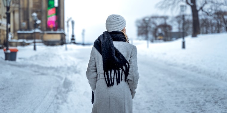 Woman walking on snowy street