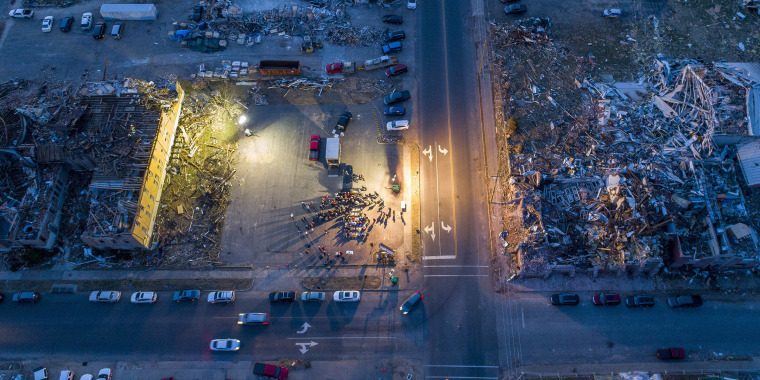 Members of Mayfield First Presbyterian Church and Mayfield First Christian Church gather in an empty lot between their destroyed churches for a joint Christmas Eve service in Mayfield, Ky., Friday, Dec. 24, 2021. A tornado devastated the community about t