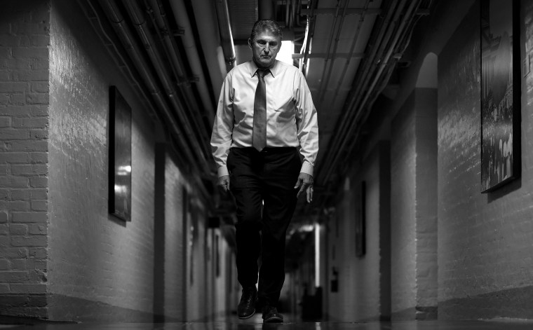 Image: Joe Manchin walks through a hallway.