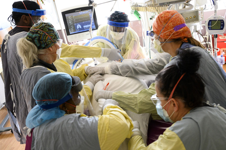 Nurses and hospital staff adjust the position of a critically-ill Covid-19 patient in the South Seven Intensive Care Unit on Dec. 8, 2021, at North Memorial Health Hospital in Robbinsdale, Minn.