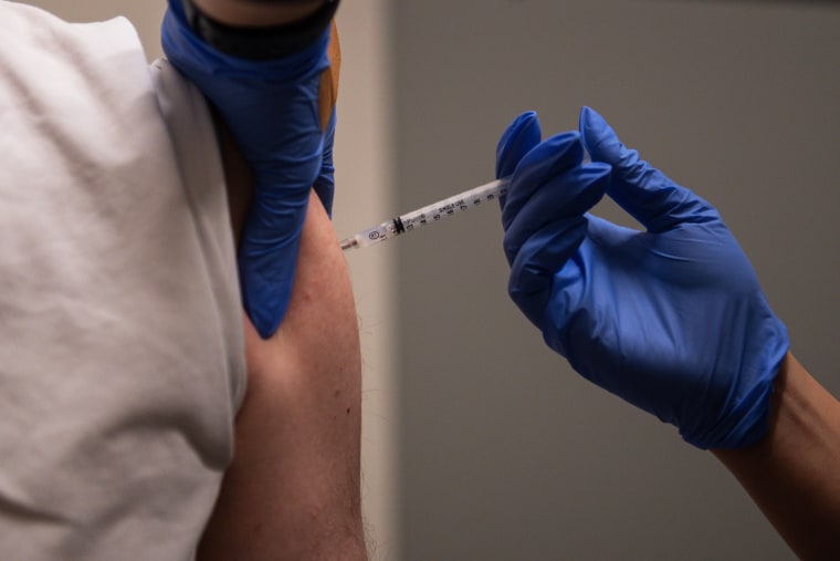 A health care worker administers a third dose of the Moderna Covid-19 vaccine in Denver on Nov. 16, 2021.