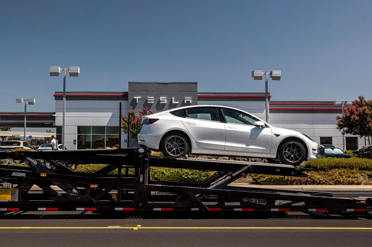 A Tesla Model 3 vehicle on an auto carrier in front of a store in Rocklin, Calif., on July 21, 2021.