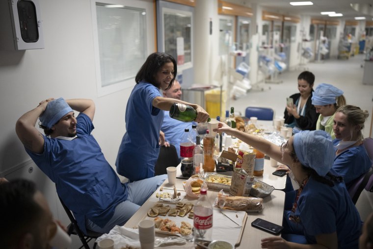 Nurse Bess Tribout, center, pours champagne to celebrate the new year in the Covid-19 intensive care unit at the la Timone hospital in Marseille, southern France.