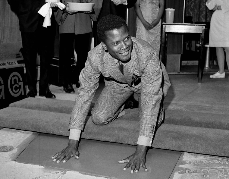 Actor Sidney Poitier, star of \"To Sir With Love,\" inscribes his signature in wet cement at Grauman's Chinese Theater in Los Angeles. The storied Hollywood Boulevard movie palace opened its doors on May 18, 1927.