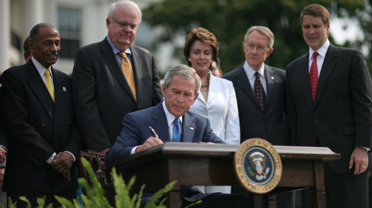 Then-President George W. Bush signs the Voting Rights Act of 2006 during a ceremony on the South Lawn of the White House in Washington on July 27, 2006.