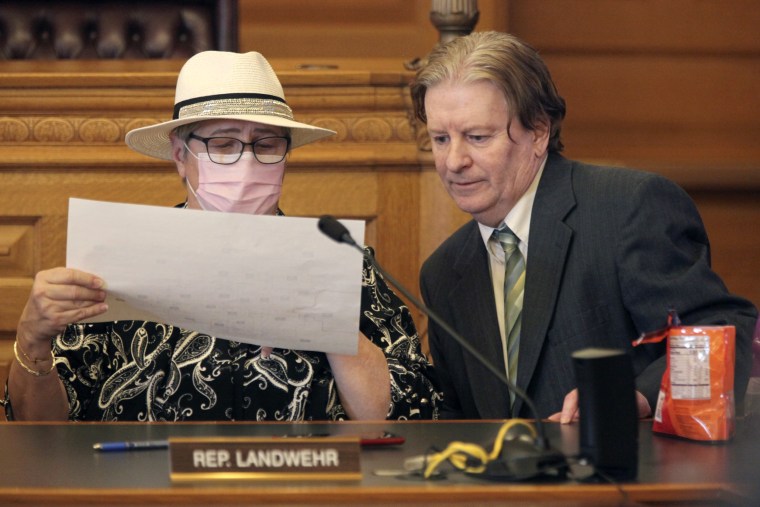 Kansas state Reps. Brenda Landwehr, left, and Steve Huebert confer during a meeting of a House committee on redistricting, on, Jan. 18, 2022, at the Statehouse in Topeka, Kan.