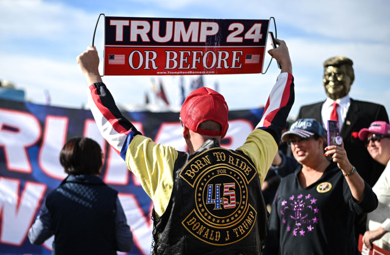 Image: Donald Trump supporter Jonathan Riches holds a "Trump 24, or before" sign ahead of the first rally of the year by former President Donald Trump on Jan. 15.