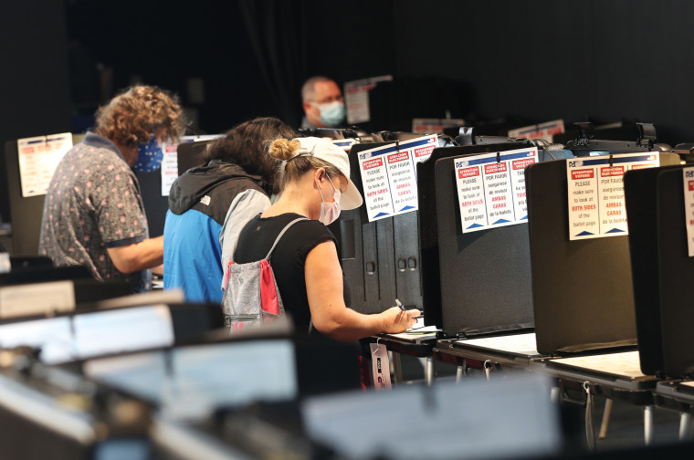 Voters fill out their ballots as they vote in Miami on Oct. 19, 2020.