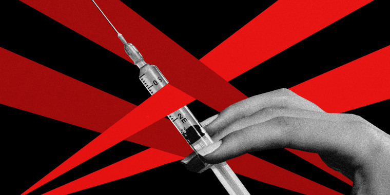 Photo illustration: A hand holding a vaccine syringe blocked by red spotlights from either sides.