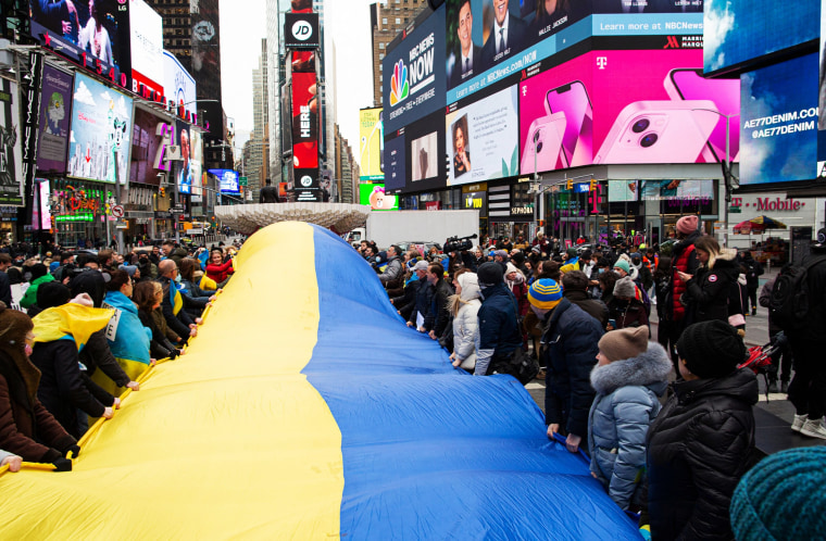 Image: Demonstrators hold a Ukrainian flag as they protest in support of Ukraine, in Times Square New York, on Feb. 24, 2022.
