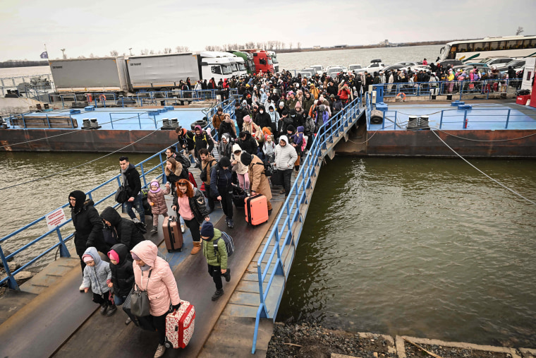 Image: People coming from Ukraine descend from a ferry boat to enter Romania after crossing the Danube river at the Isaccea-Orlivka border crossing between Romania and Ukraine on Saturday.