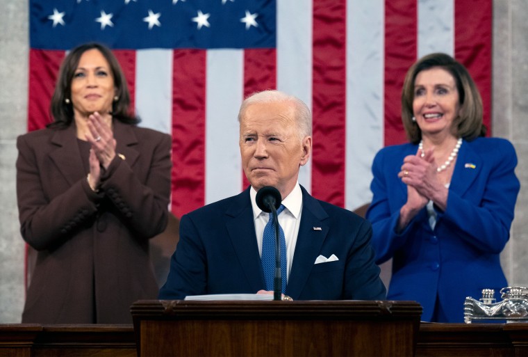 Image: Kamala Harris and Nancy Pelosi applauding in the background as Joe Biden delivers his State of the Union address.