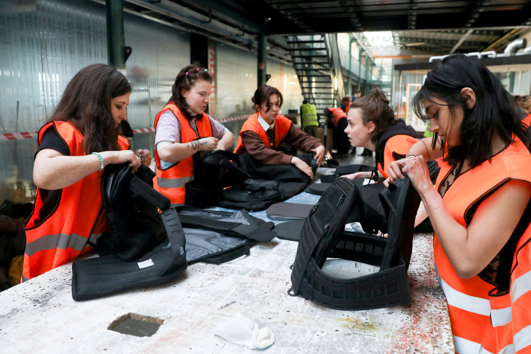 Image: Volunteers assemble flak jackets in a warehouse in Prague