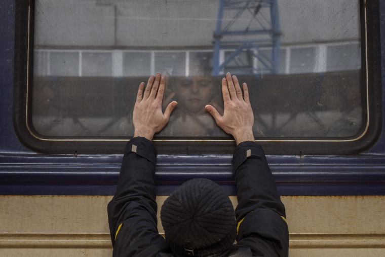 Image: Aleksander, 41, presses his palms against the window as he says goodbye to his daughter Anna, 5, on a train to Lviv at the Kyiv station, Ukraine, on March 4. 2022.