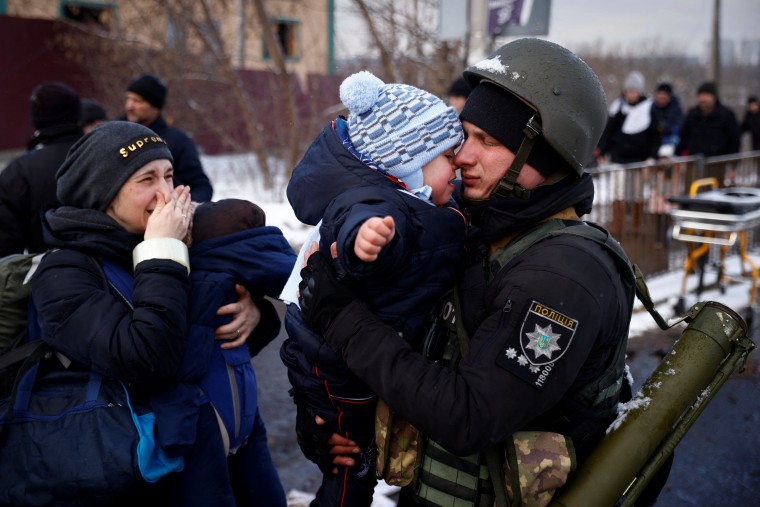 A Ukrainian police officer says goodbye to his son as his family flees from advancing Russian troops in the town of Irpin outside Kyiv on Tuesday.
