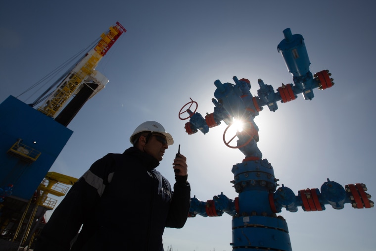 Image: A worker speaks on a handheld transceiver at a gas well near to the Gazprom PJSC gas drilling rig near Irkutsk, Russia, on April 7, 2021.