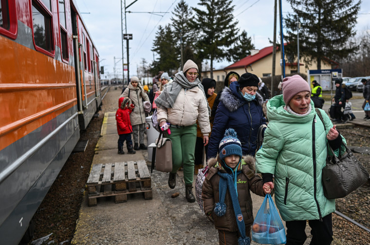 Image: Women and children walk to board a train to the Przemysl main train station after crossing the Polish Ukrainian border crossing in Medyka, Poland, on Thursday.