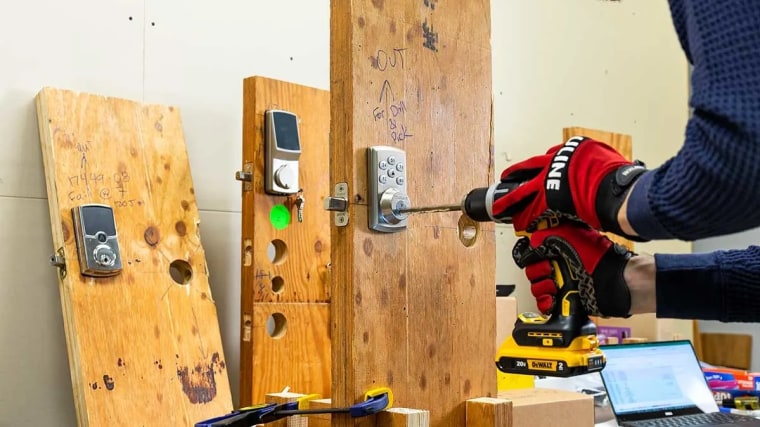 A Consumer Reports engineer uses a cordless drill to test door locks.