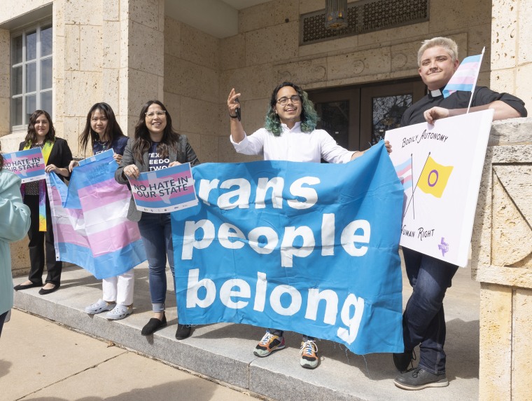 Adri Perez, ACLU of Texas Policy and Advocacy Strategist, center, and other LGBTQ leaders speak outside the Travis County courthouse where a hearing was held to stop the child welfare investigations targeting supportive families of transgender children on