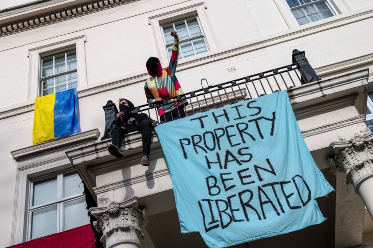 Protesters occupy a building reported to belong to Russian oligarch Oleg Deripsaka on Monday in London.