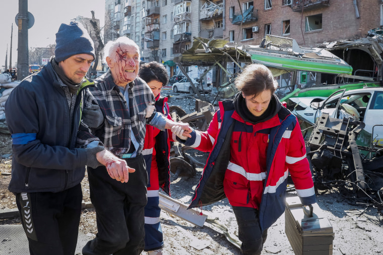 Medics help an elderly resident, wounded as a result of shelling at a residential building in Kyiv on Monday.