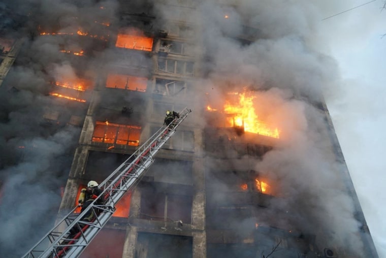 Rescuers work next to a residential building damaged by shelling in Kyiv, Ukraine on Tuesday.