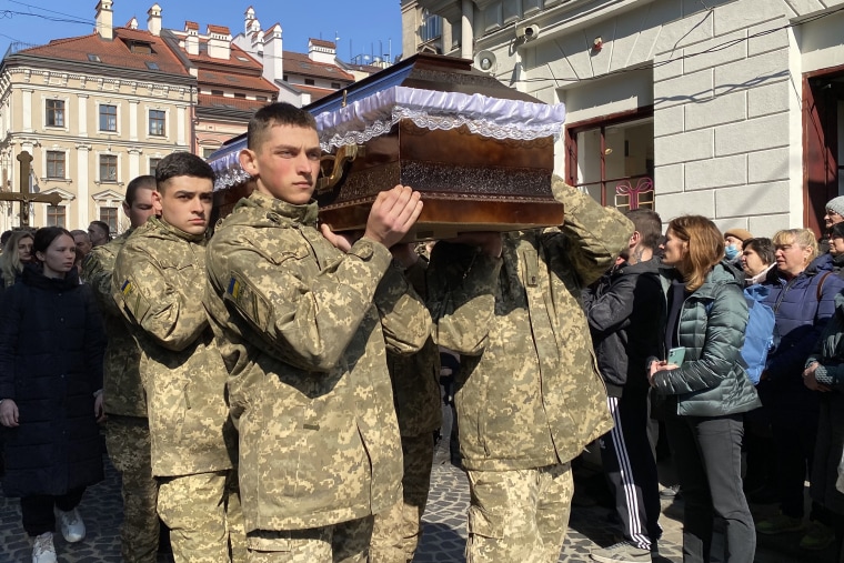 Image; Ukrainian soldiers carry a coffin during a service for four killed in Sunday's air raid, outside the Church of the Most Holy Apostles Peter and Paul, in Lviv, Ukraine.