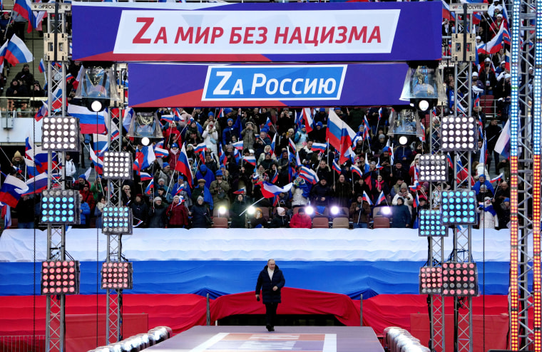 Russian President Vladimir Putin walks out on the stage at concert marking the eighth anniversary of the annexation of Crimea in Moscow on Friday.