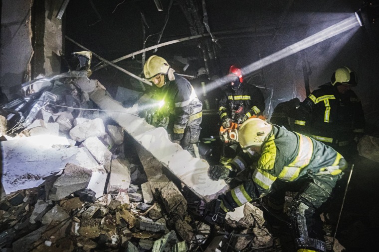 Rescuers work at the site of a shopping mall damaged by an airstrike in Kyiv, Ukraine in images released Monday.