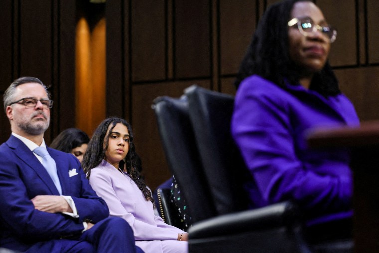 Leila Jackson, daughter of Judge Ketanji Brown Jackson, listens next to her father and Judge Jackson's husband, Patrick Jackson, as Judge Jackson appears before a Senate Judiciary Committee hearing on her nomination to the Supreme Court on Capitol Hill on