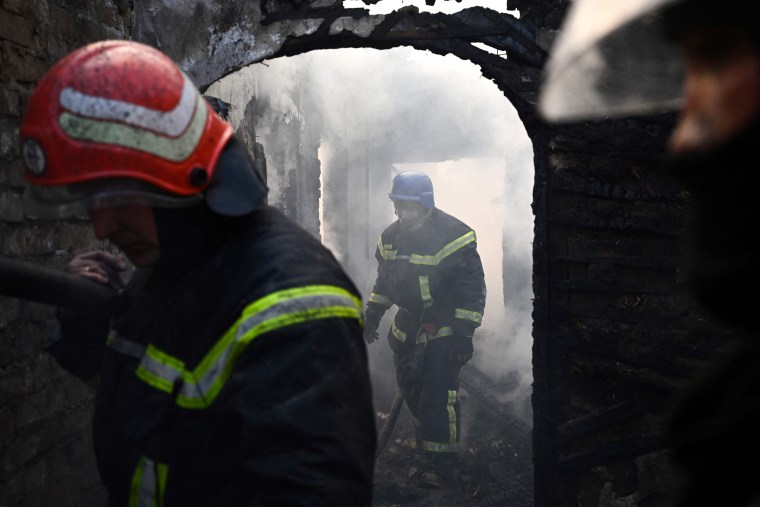 Firefighters extinguish a burning house hit by Russian Grad rockets in Kyiv, on Tuesday.