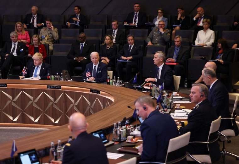 President Joe Biden listens as NATO Secretary General Jens Stoltenberg addresses the floor during a summit in Brussels on Thursday.