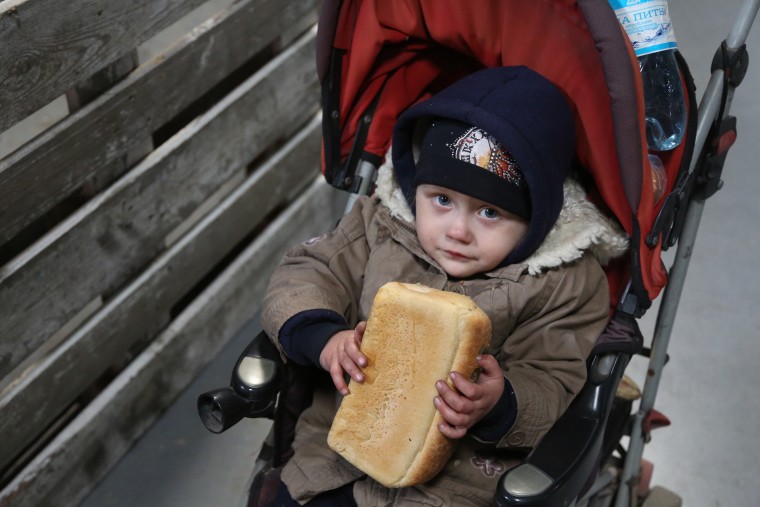 A child holds a loaf of bread as civilians are evacuated along humanitarian corridors from the Ukrainian city of Mariupol on Thursday.