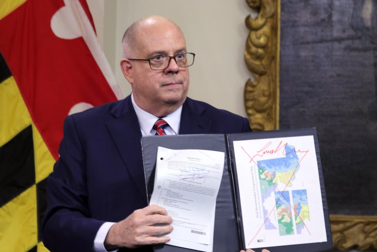 Maryland's Republican Gov. Larry Hogan shows a copy of the redrawn congressional map approved by the General Assembly, right, that is crossed out in red, during a news conference where he announced his veto of the plan, in Annapolis, Md., on Dec. 9, 2021.