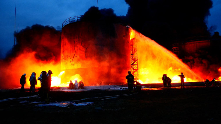 This handout photograph taken and released by the Ukrainian State Emergency Service on March 27, 2022 shows the firefighters putting out a fire after Russian missiles strikes to infrastructure including a fuel storage facility on the western Ukrainian cit