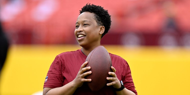 Image: Assistant Running Backs Coach Jennifer King looks holding a football.