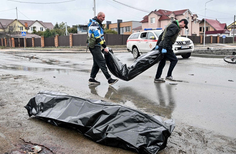 Communal workers carry body bags to a van following Russian shelling of the town of Bucha, near Kyiv, Ukraine, on April 3, 2022.