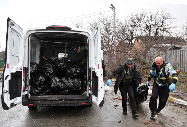 Communal workers carry the body of a civilian man killed by Russian shelling in Bucha, Kyiv oblast, Ukraine, on on April 3, 2022.