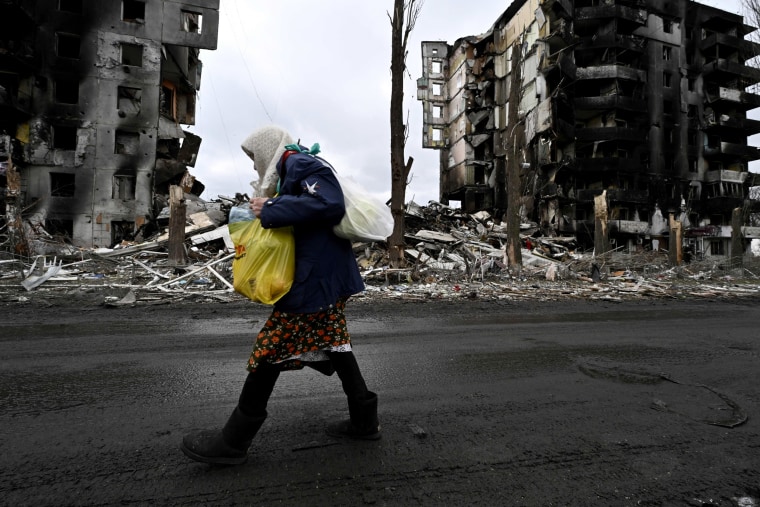 Image: A woman walks past a destroyed building in Borodianka, Ukraine, on April 6, 2022.