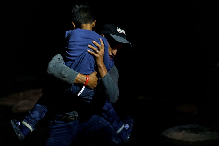 Image: Honduran migrant Eric Villanueva carries his son, Eric, 7, onto the shore of the Rio Grande after crossing the border into the United States from Mexico on July 9, 2021.