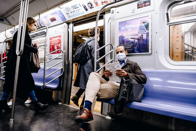 A passenger reads while riding the L train in New York on April 13, 2021.