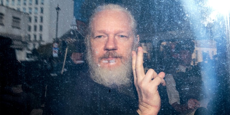 Image: Julian Assange gestures to the media from a police vehicle on his arrival at Westminster Magistrates court, in London, on April 11, 2019