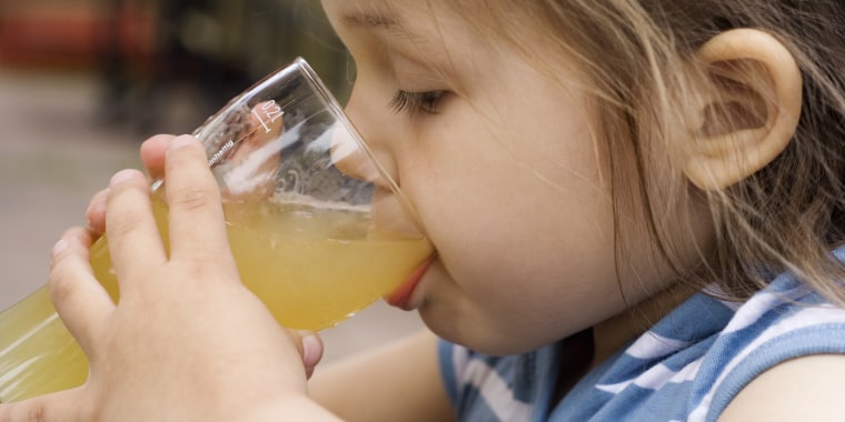 Little girl drinking a glass of juice