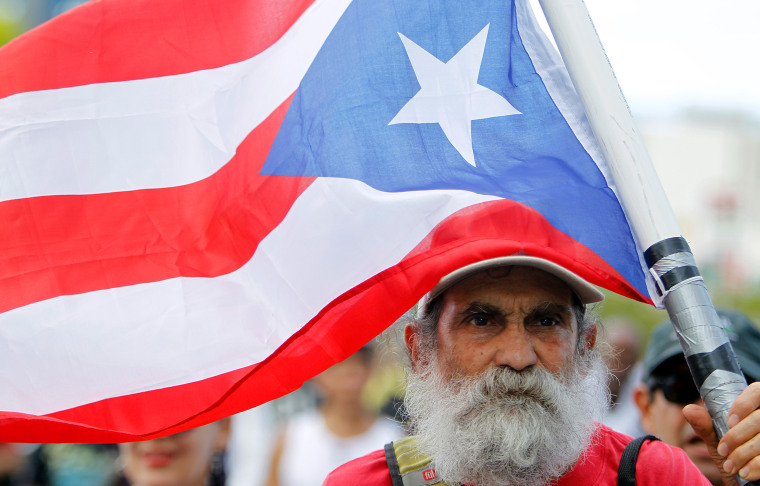 Image: A man carrying a Puerto Rican flag.