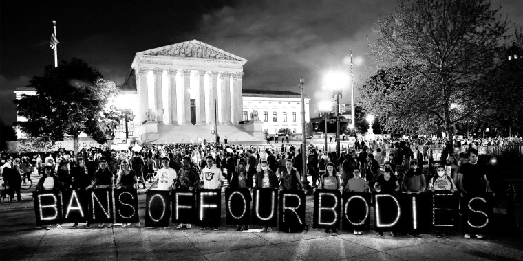Image: Activists rallying outside the Supreme Court holding up single boards that spell out,\"Bans off our bodies\".