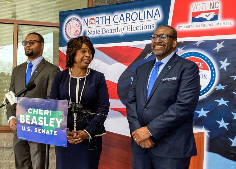 Democratic U.S. Senate candidate Cheri Beasley, center, laughs with husband Curtis Owens, right, while son Matthew Owens, watches, before she speaks with reporters at the North Carolina State Fairgrounds in Raleigh, N.C., on Feb. 24, 2022.