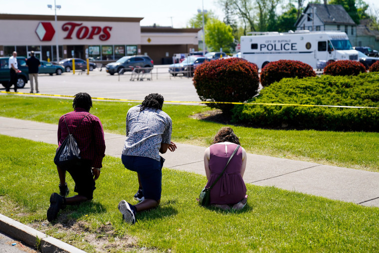 Image: Mourners kneel at the scene of a mass shooting that left 10 dead in Buffalo, N.Y., on May 15, 2022.