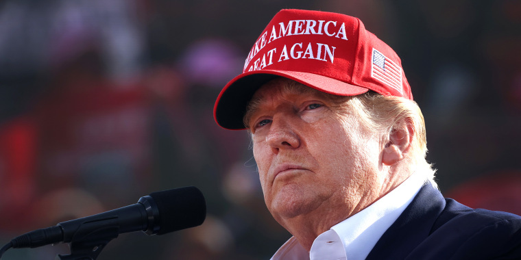 Image: Donald Trump wearing a red hat that reads, \"Make America Great Again\".